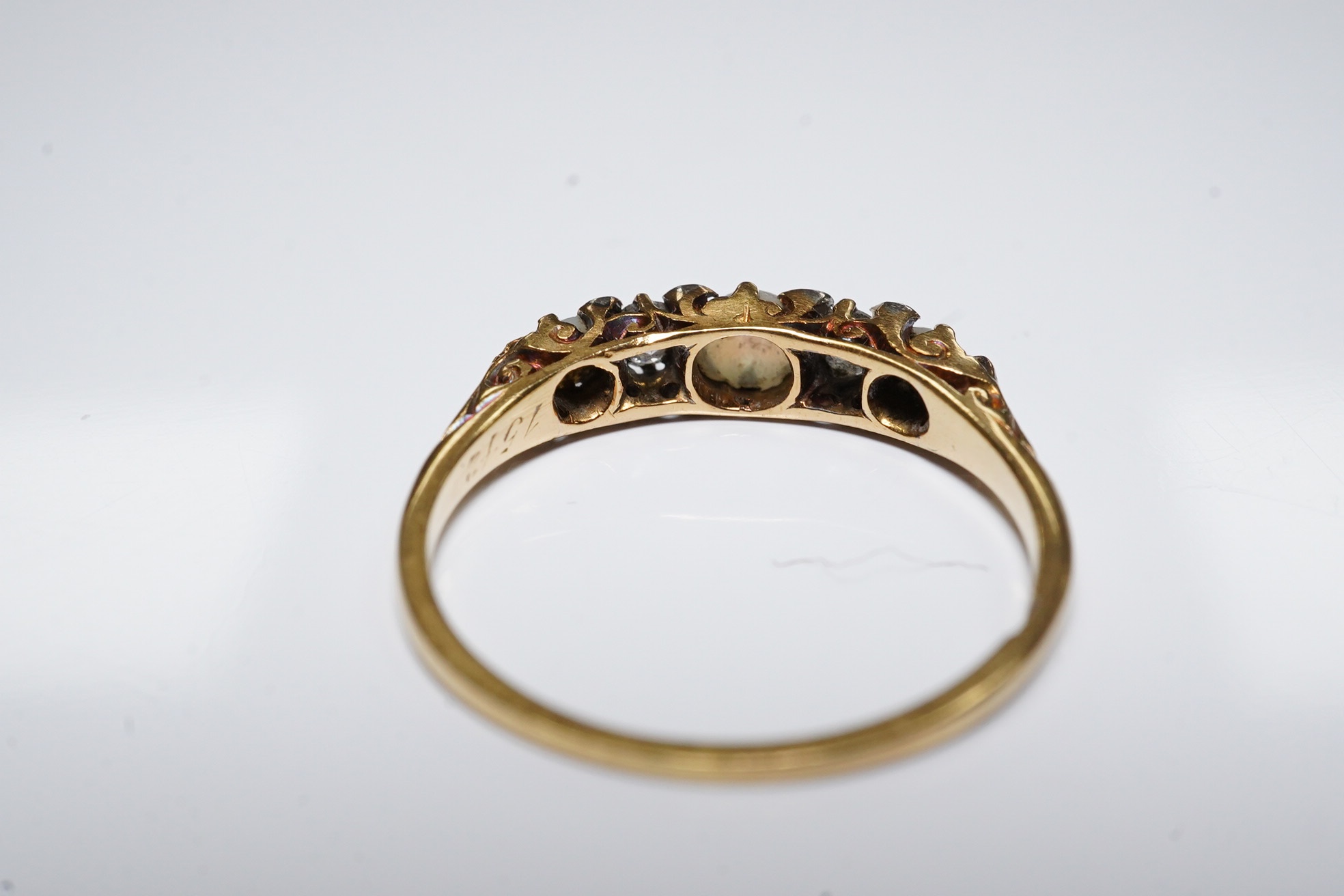 An early 20th century yellow metal (stamped 18), two stone diamond and three stone split pearl set half hoop ring, size O, gross weight 2.2 grams. Condition - fair